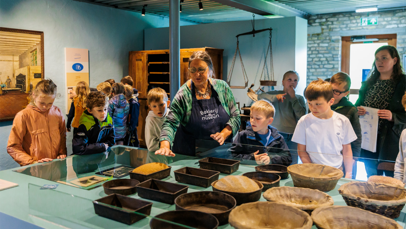 Kinderen bakken in het bakkerijmuseum