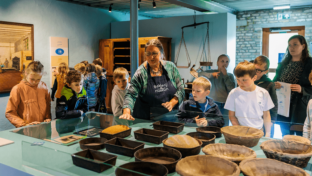 Kinderen bakken in het bakkerijmuseum