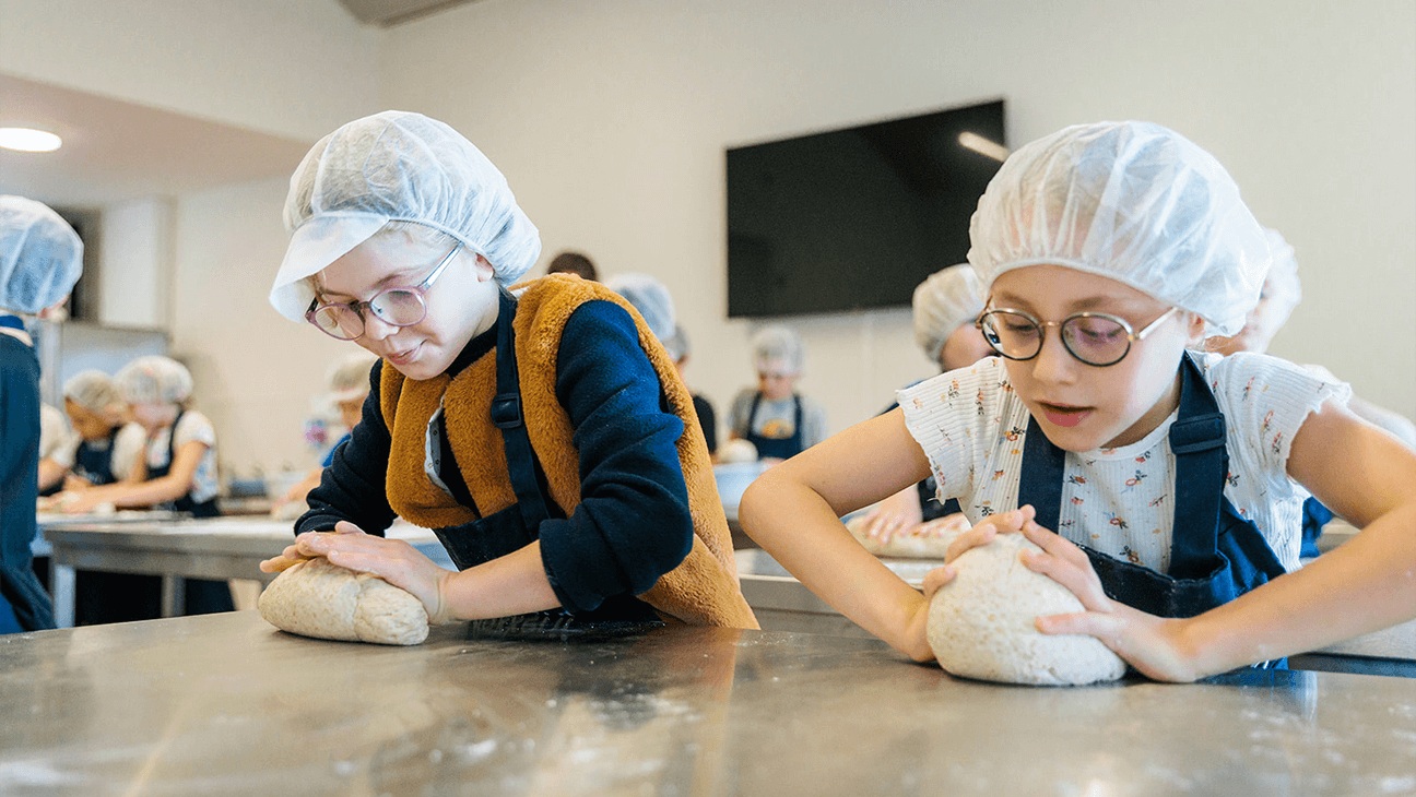 Kinderen kneden brood in het bakkerijmuseum