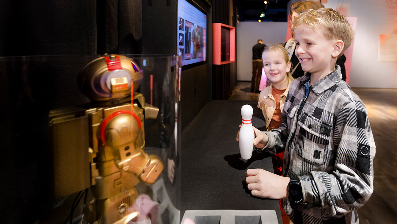 Jongen met bowlingkegel in zijn hand in het Discovery museum