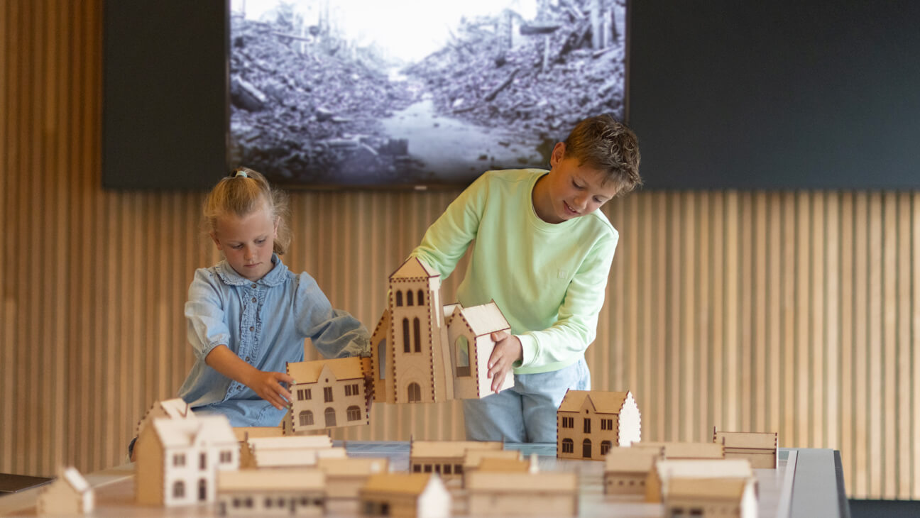 Kinderen bouwen stad Nieuwpoort met houten huizen in Westfront te Nieuwpoort