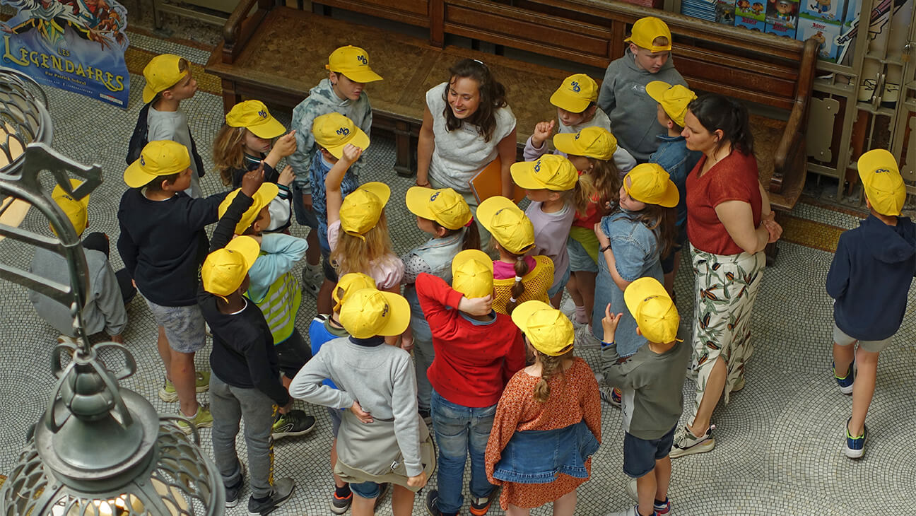 Klas met gele petjes in het stripmuseum