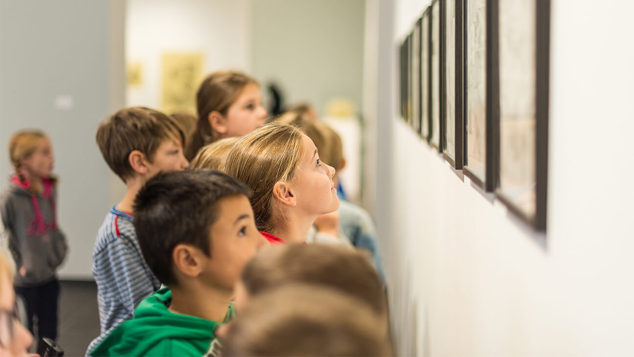 Klas kijken naar schilderijen in een zaal in S.M.A.K.