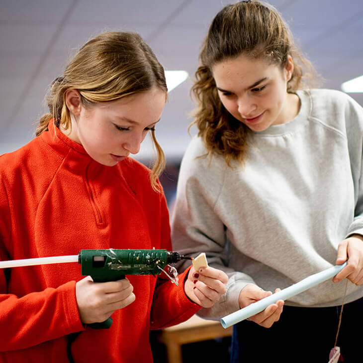 Met het lijmpistool geven de leerlingen hun microraket vleugeltjes tijdens hun klasbezoek aan Euro Space Center