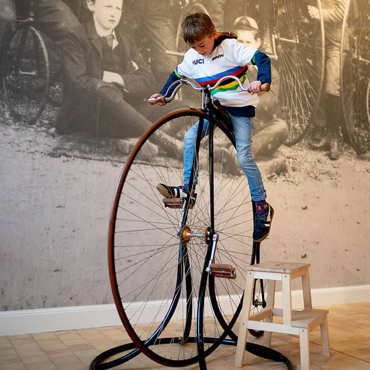 Leerling test oude fiets tijdens zijn klasbezoek aan KOERS. Museum van de Wielersport