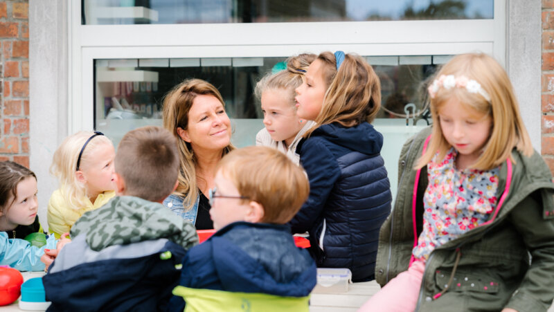 directeur Rebekka Buyse tussen haar leerlingen op de speelplaats, kangoeroewerking voor cognitief sterk functionerende werking