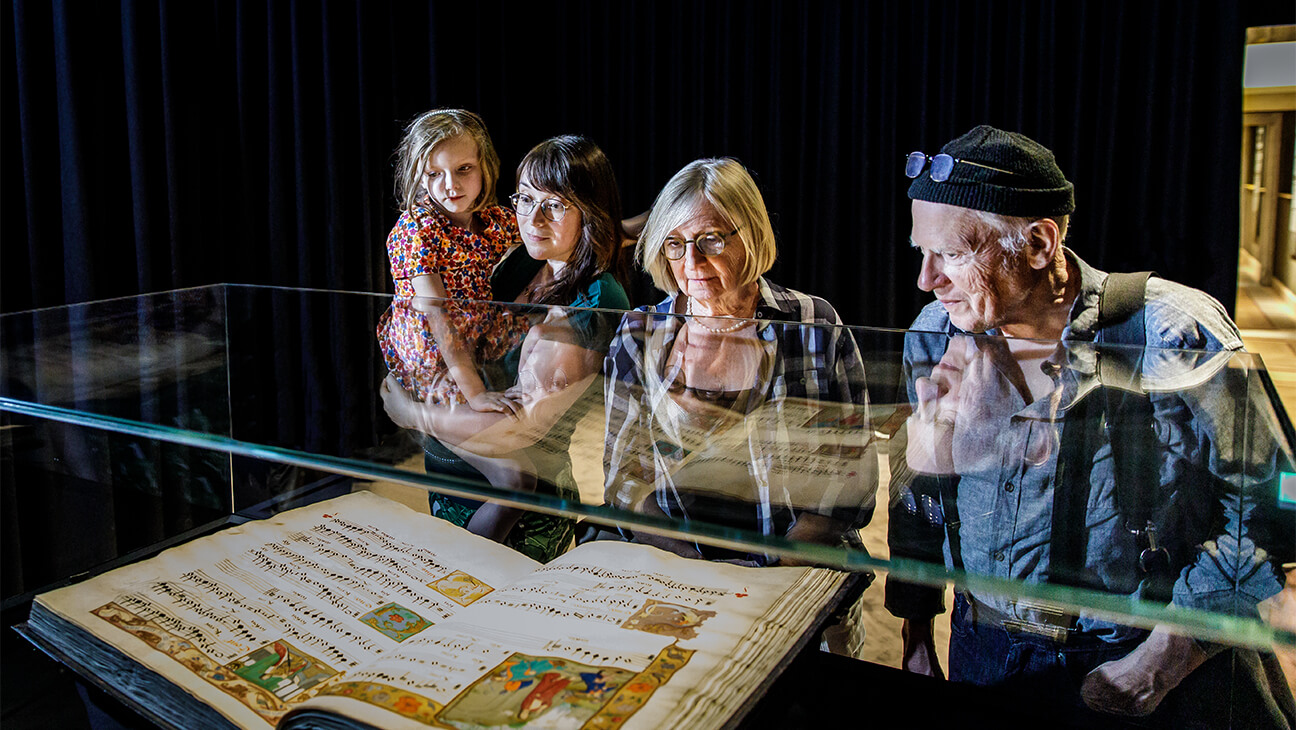 Bezoekers kijken naar een oud boek in hof van busleyden