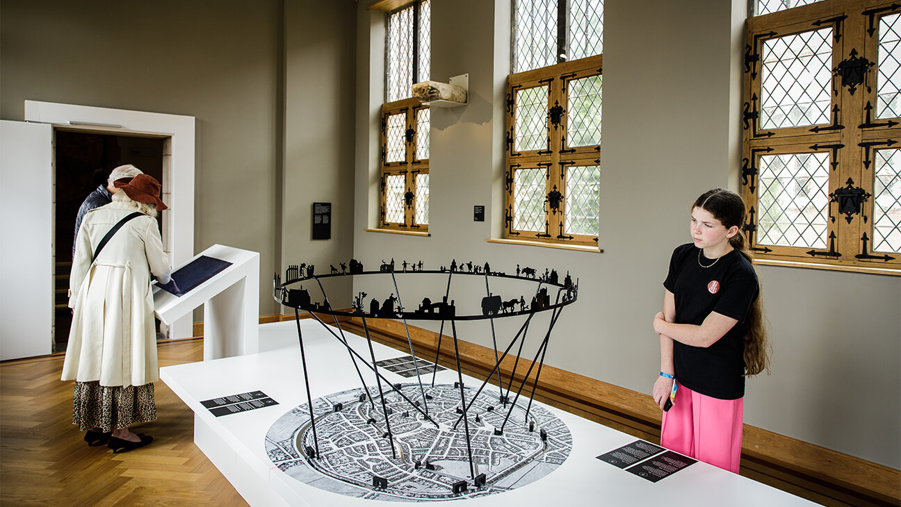 Bezoeker kijkt naar metalen kunstwerk in hof van busleyden