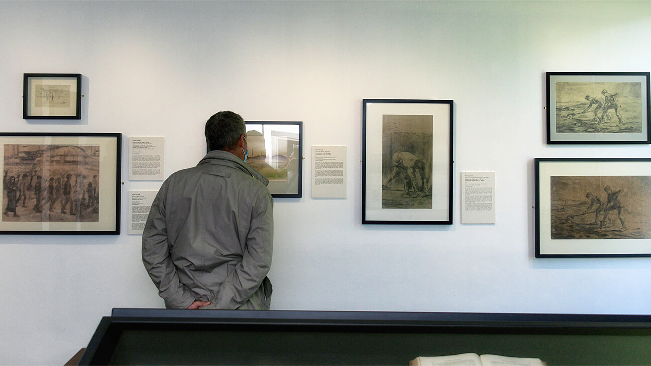 Bezoeker kijkt naar schilderijn in Maison Van Gogh
