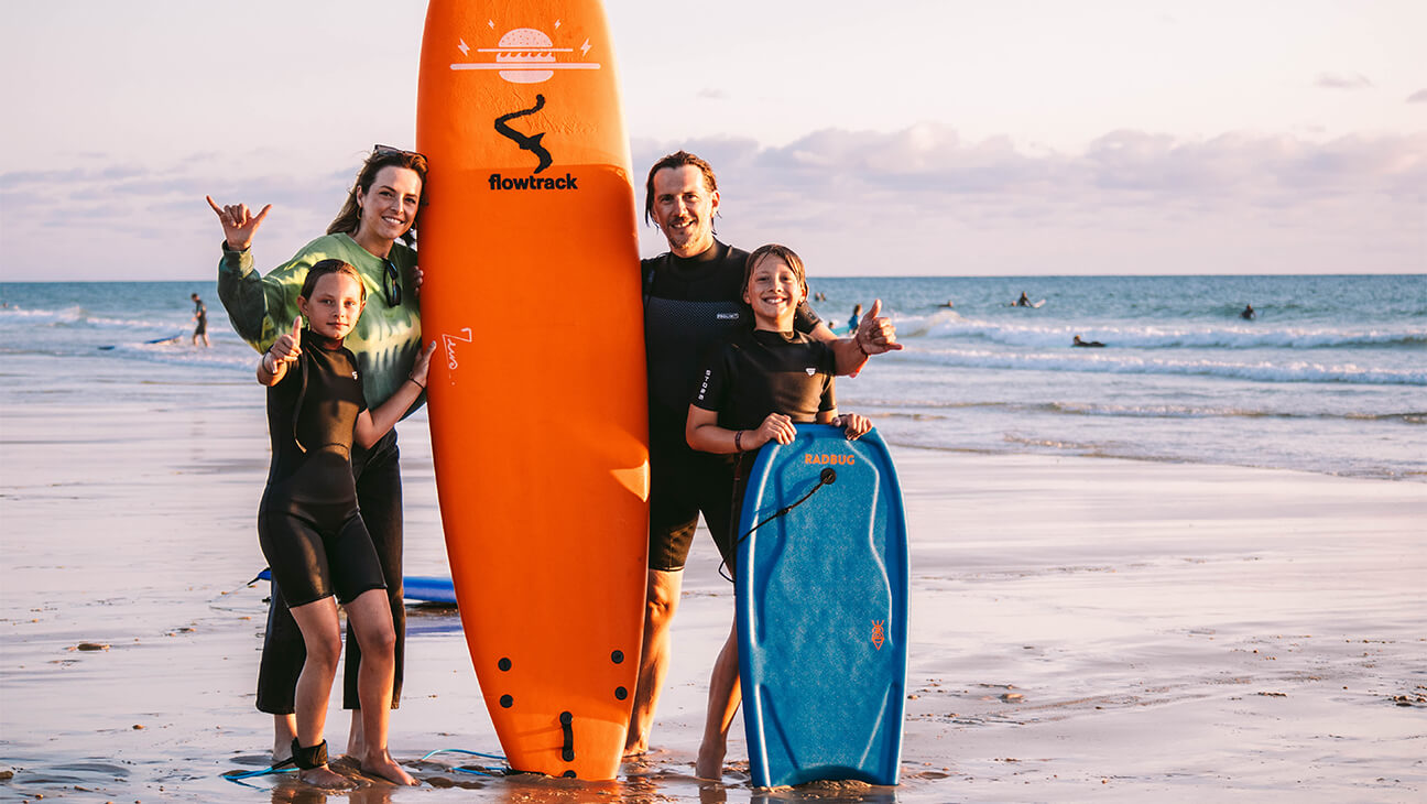 Gezin poseert bij surfplanken