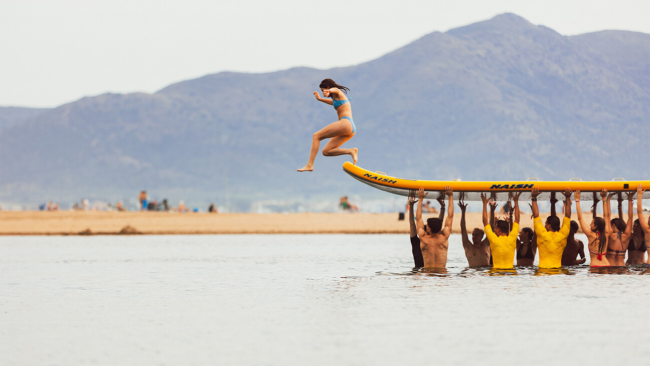 Vrouw springt van een surfplank