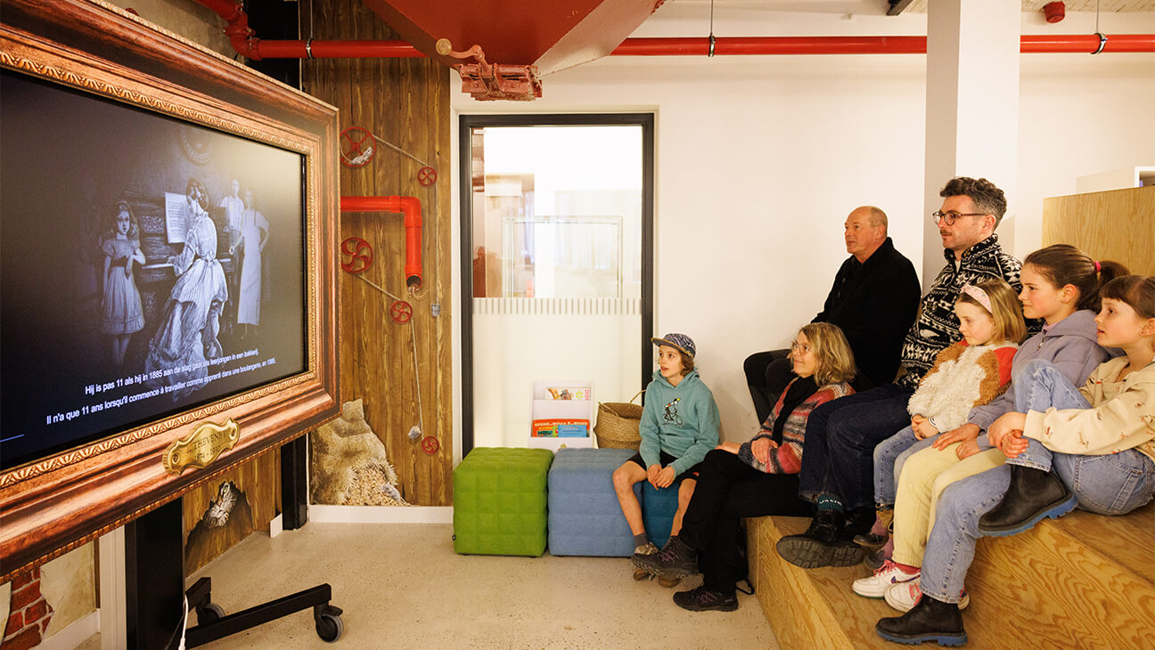 Bezoekers kijken naar video op de Expo Louis Thevenet. Een leven in kleur