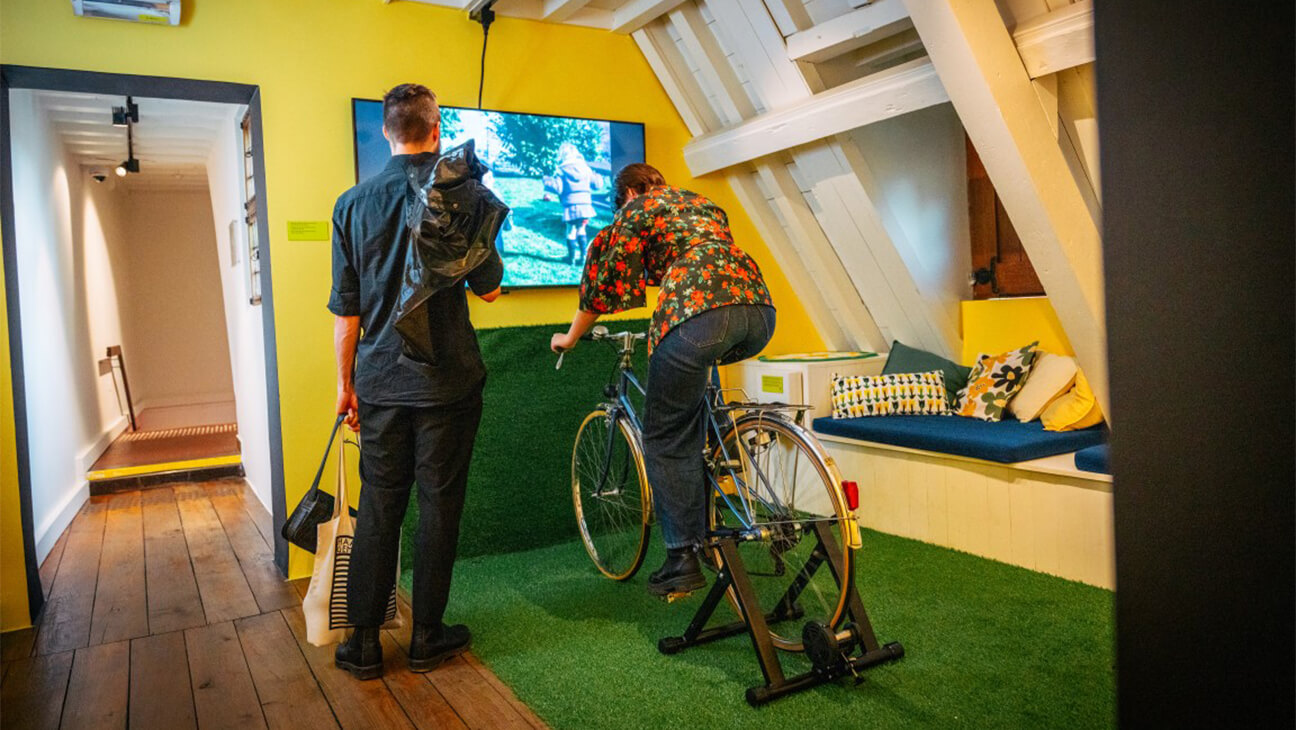 Vrouw rijd op fiets in zaal van Expo Ja santé!