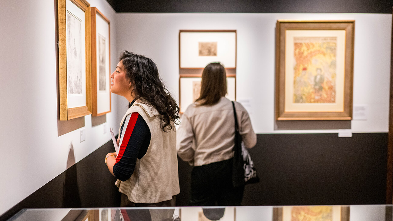 Bezoekers kijken naar een schilderij tijdens de Expo Staten van verbeelding