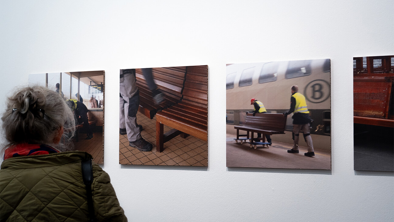 Vrouw kijkt naar foto's van werkzaamheden bij nmbs