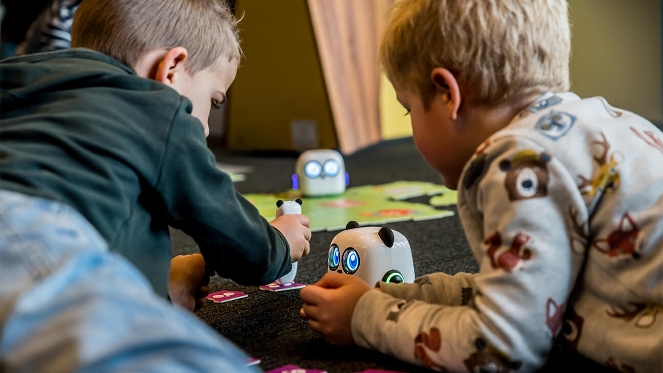 Jongens spelen met speelgoedrobots in technopolis