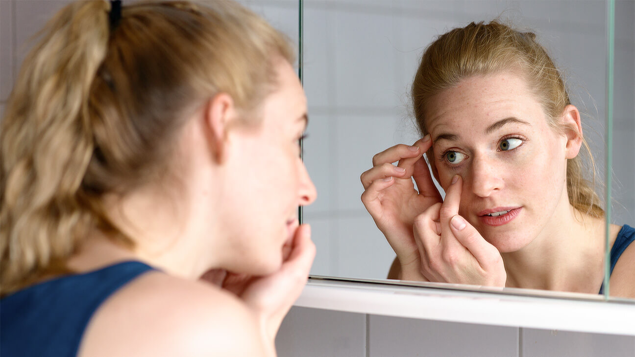 Vrouw steekt contactlens in