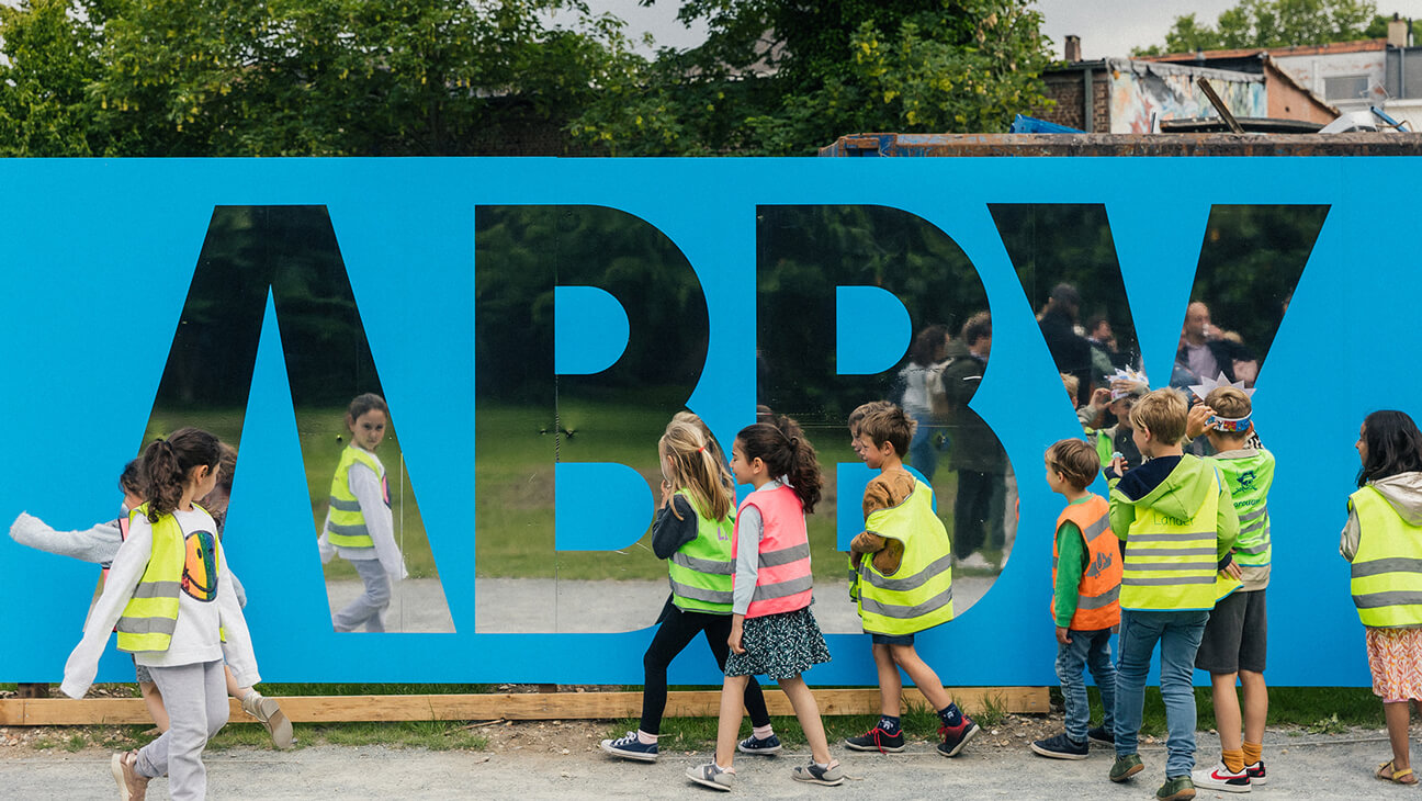 Leerlingen wandelen langs logo ABBY