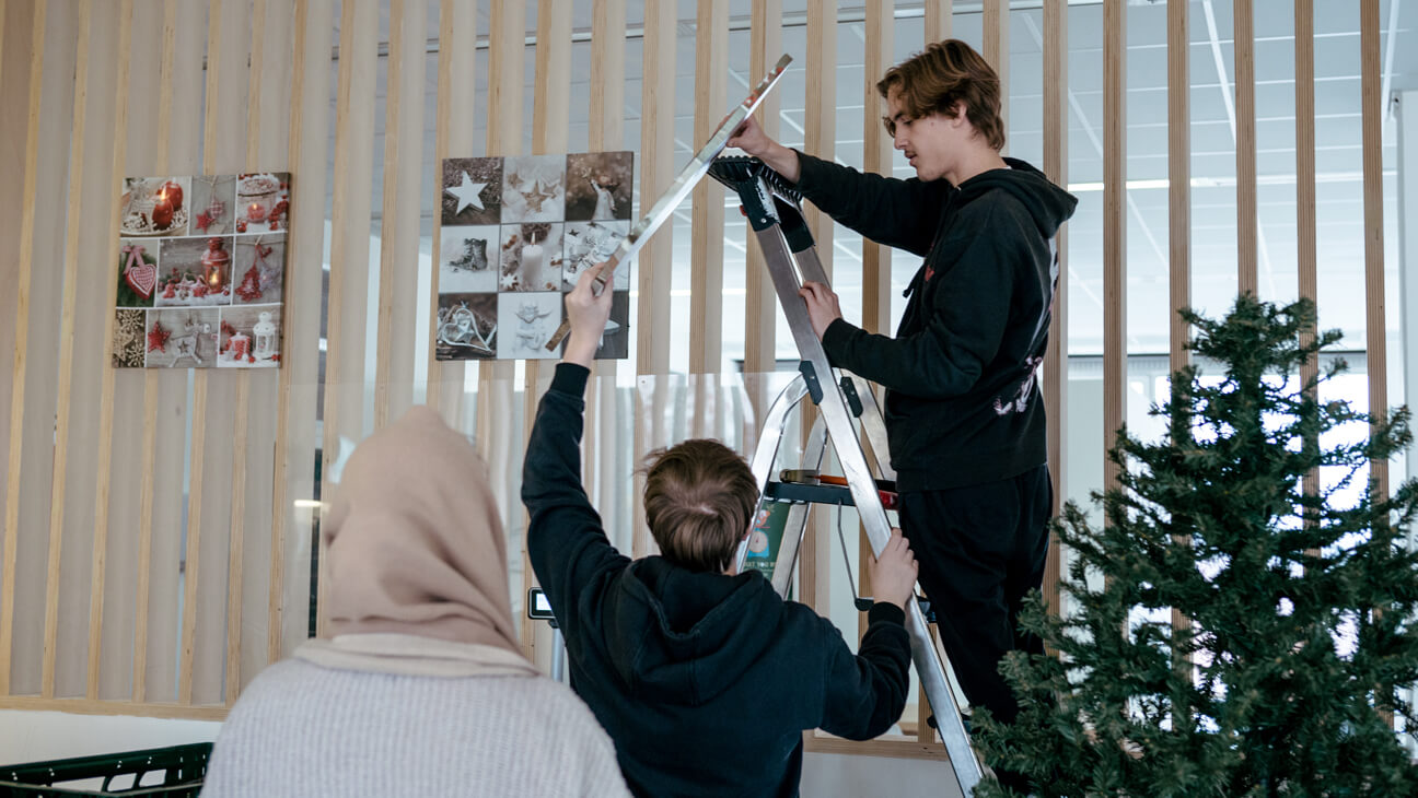 Leerlingen hangen kerstdecoratie op in hun leeronderneming Starbox 